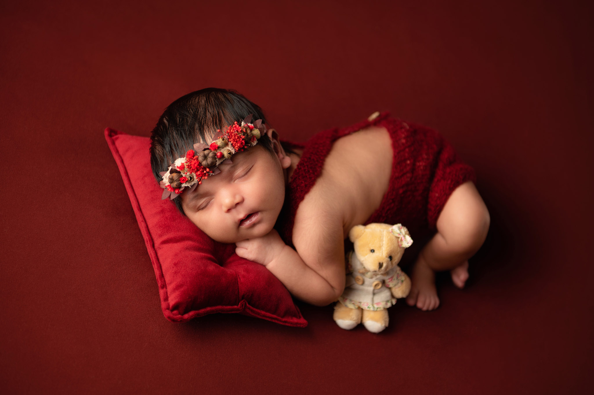 Newborn baby girl on red photo shoot