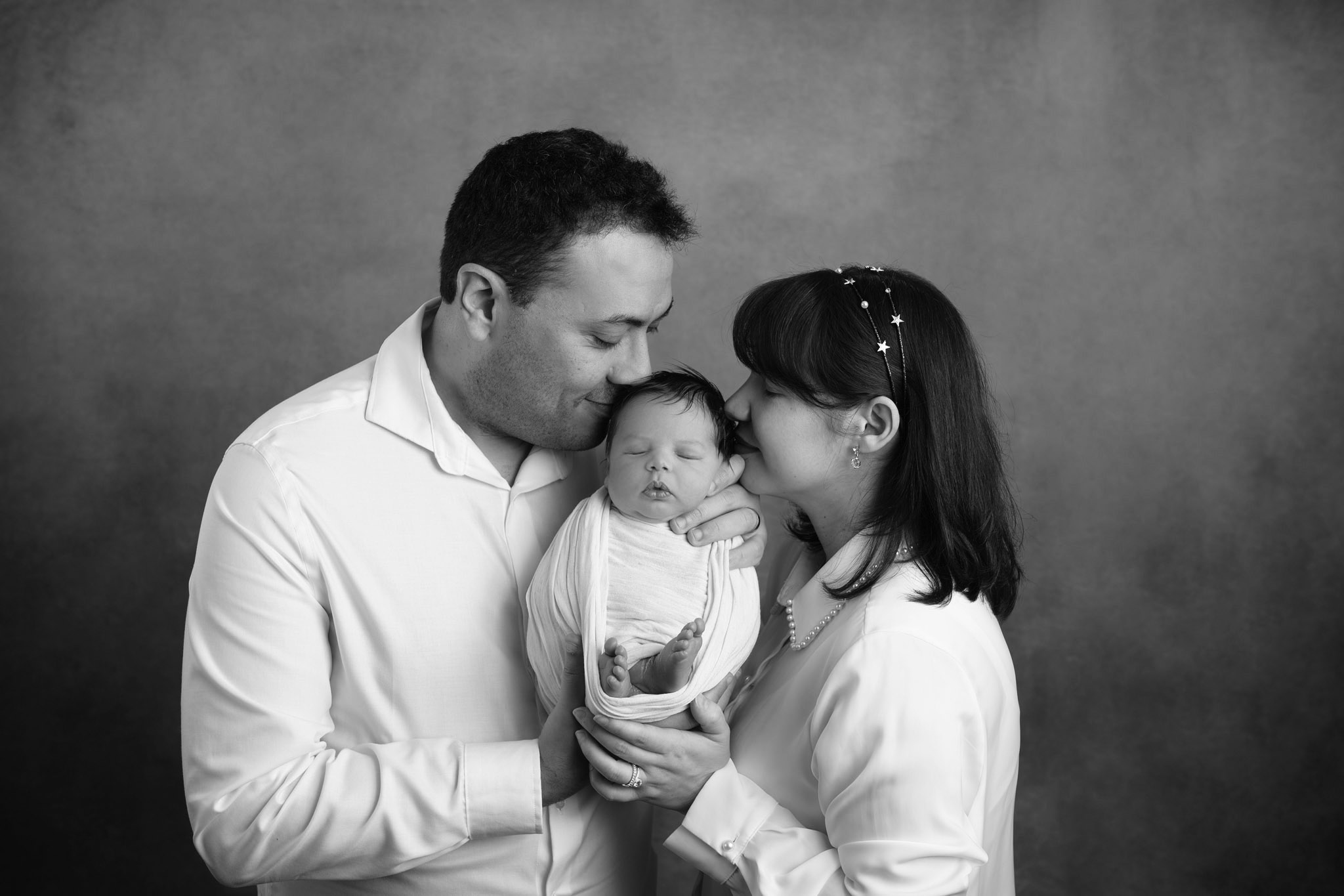 Parents posing with newborn baby