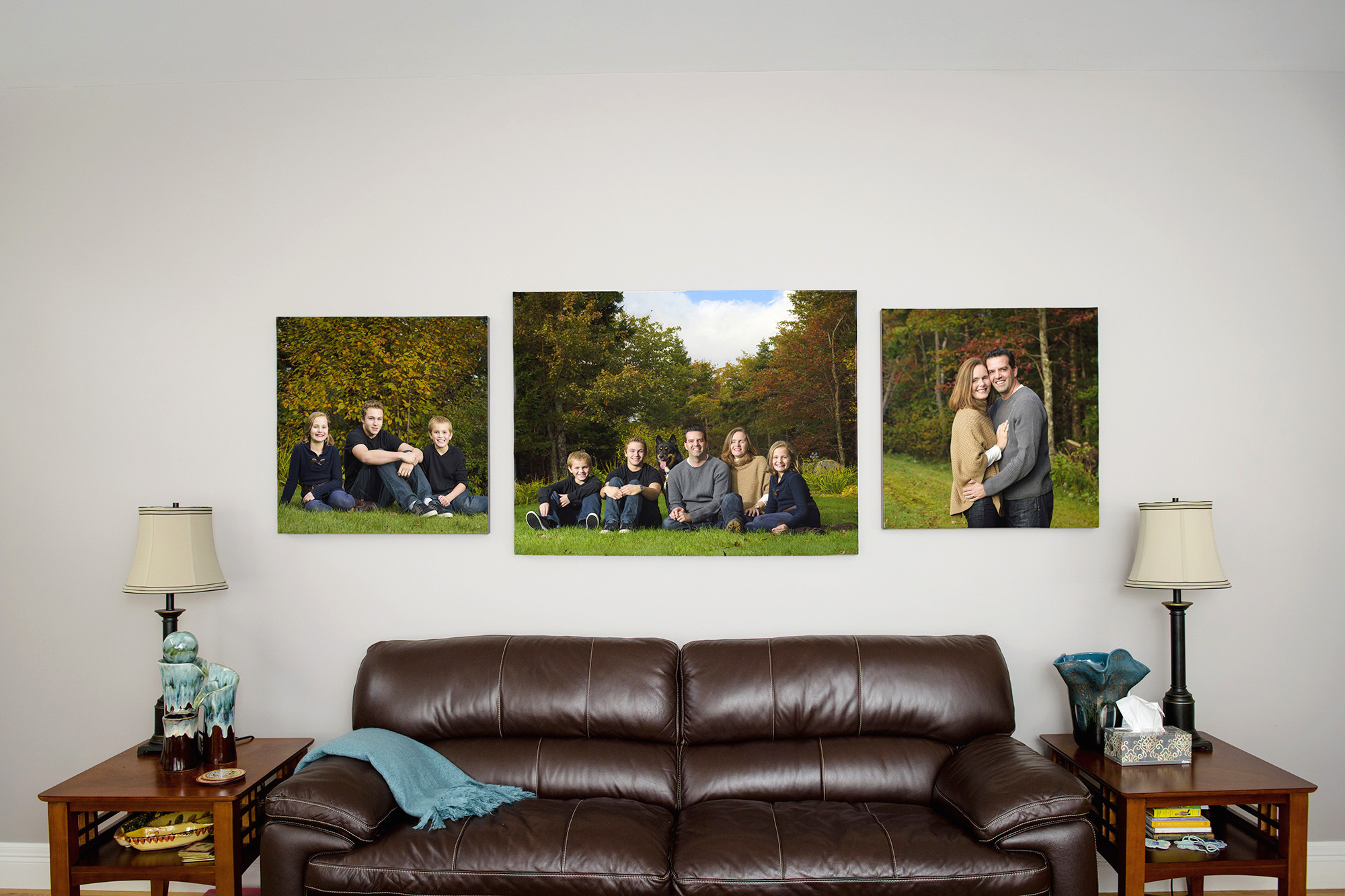 Family couch with three canvas prints hung above it featuring family portraits