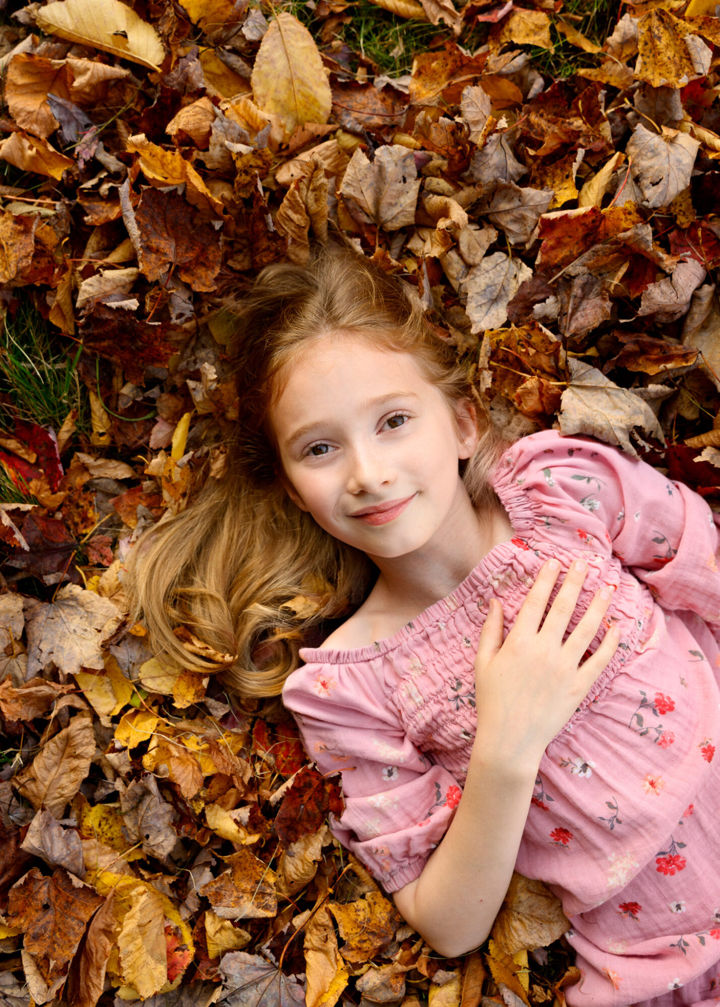 girl lying down in fall leaves photo shoot