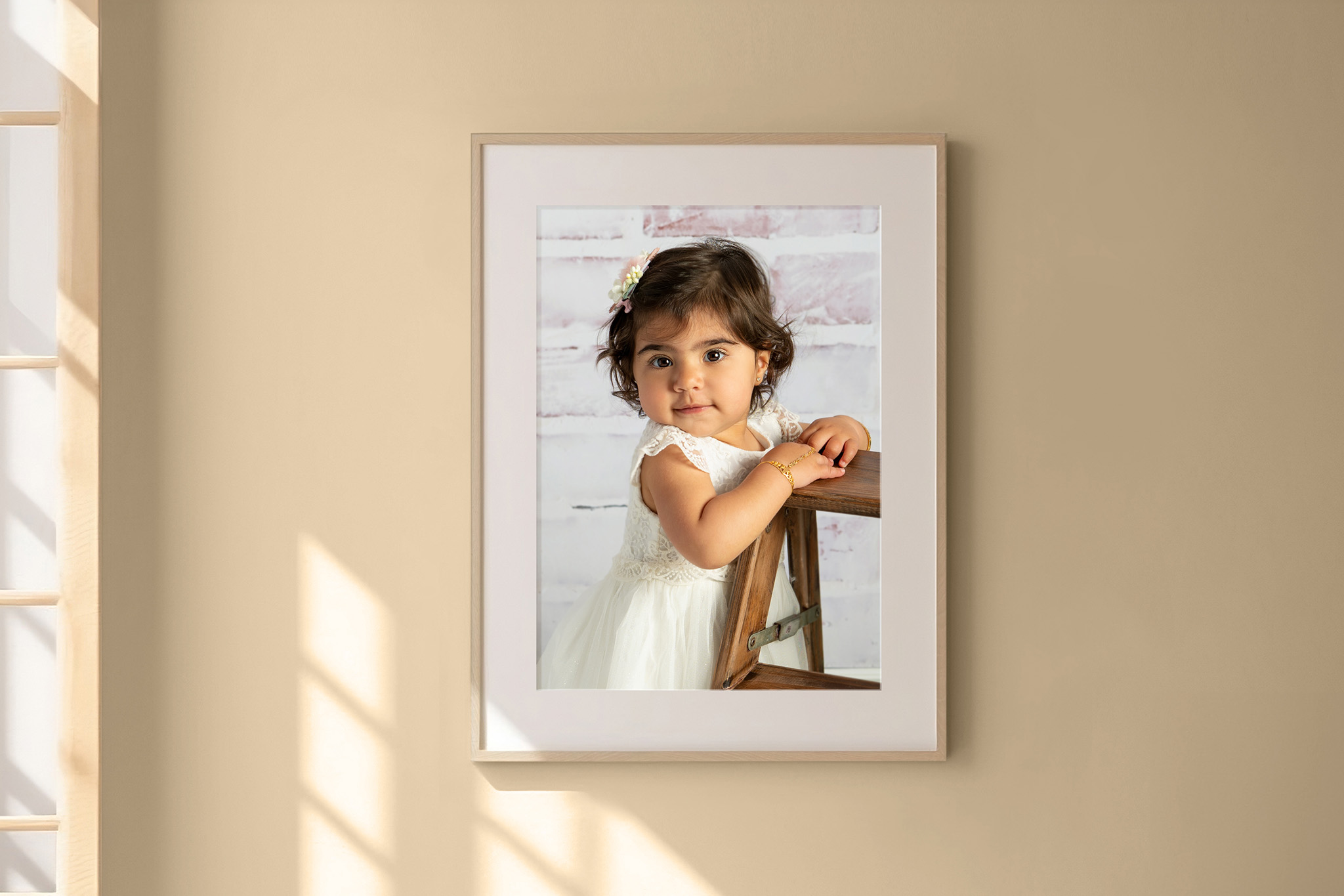 framed photo hanging on a wall of a little girl in a white dress