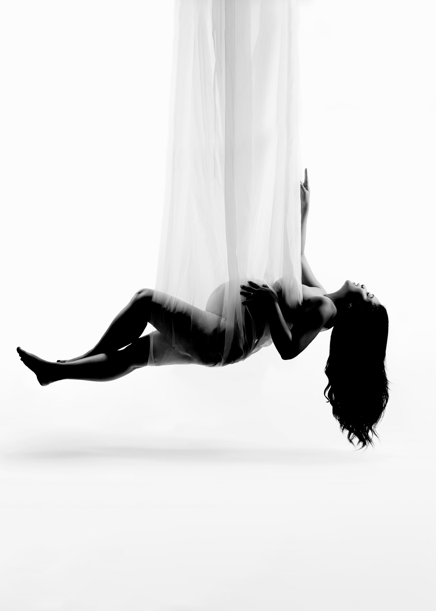 photo of pregnant woman suspended in a fabric swing