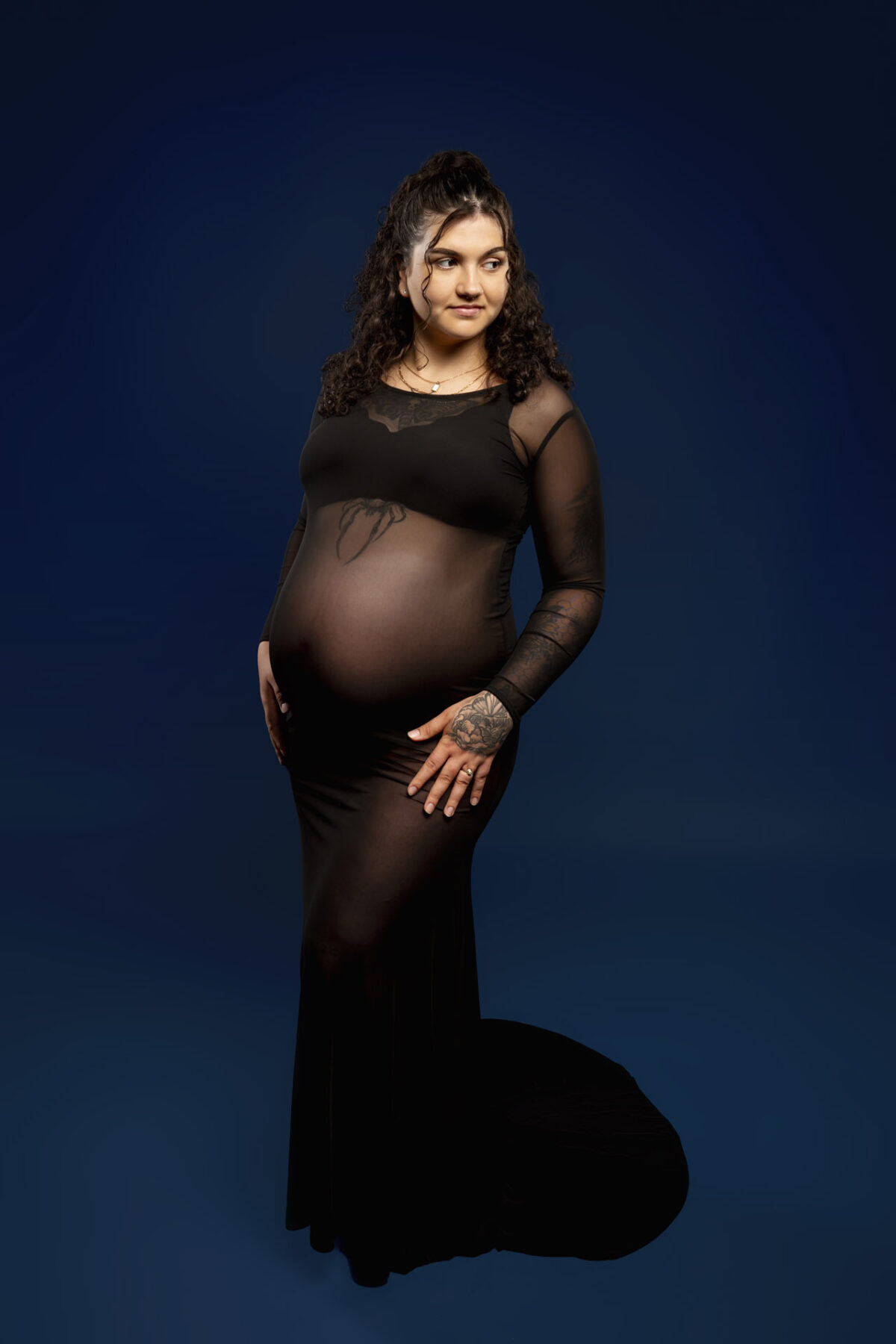 Pregnant woman wearing black mesh maternity photo shoot dress
