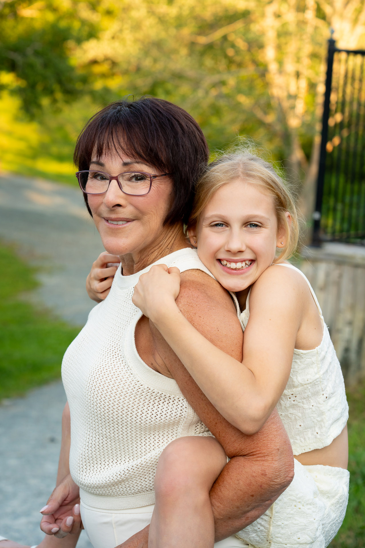 Fun family photography session. Grandmother giving a piggy back to granddaughter