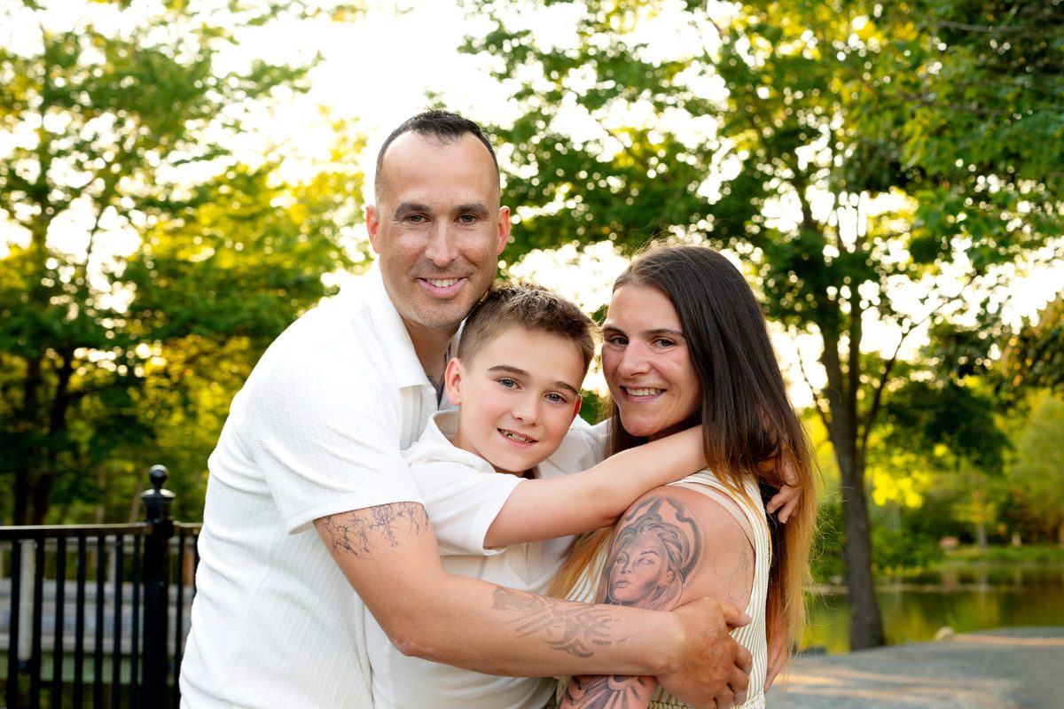 hug sandwich of smiling family of three at Shubie Park in Dartmouth